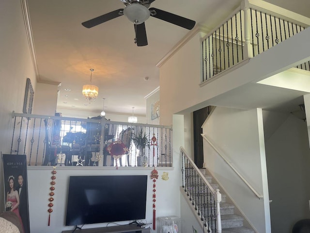 interior space featuring ceiling fan with notable chandelier and crown molding