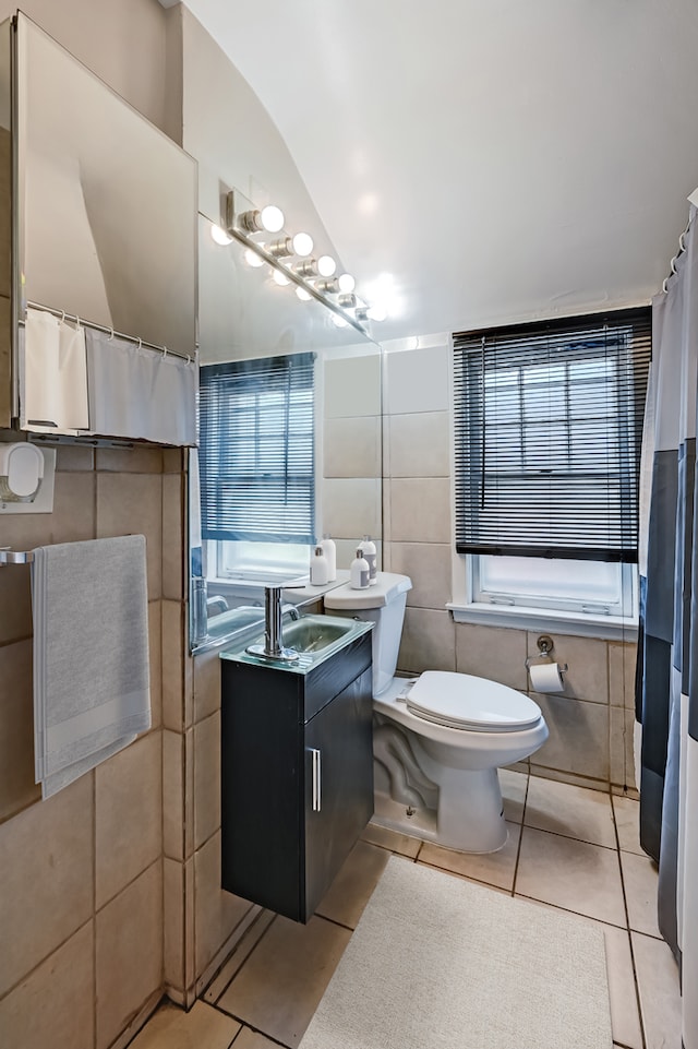 bathroom featuring toilet, tile patterned floors, vanity, tile walls, and a shower with shower curtain