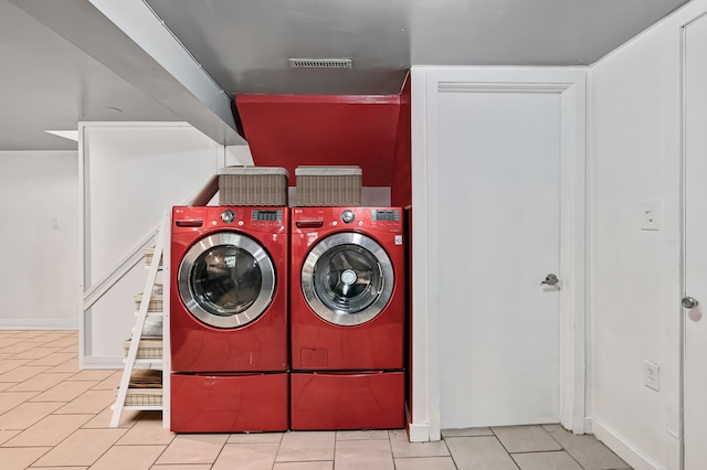 laundry area with light tile patterned flooring and washing machine and dryer