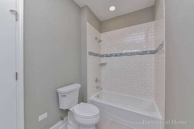 bathroom with tile patterned flooring, tiled shower / bath combo, and toilet