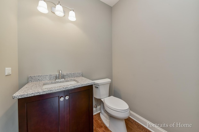 bathroom with hardwood / wood-style floors, vanity, and toilet