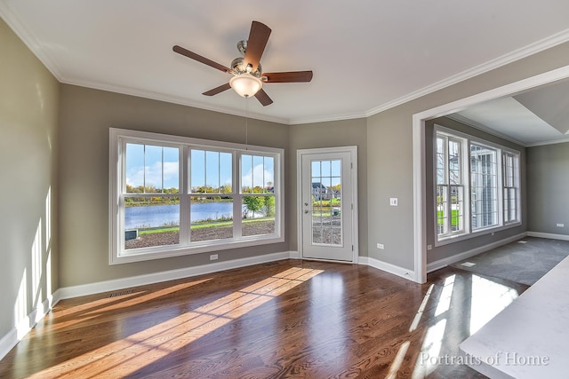 interior space featuring ceiling fan, a water view, and ornamental molding