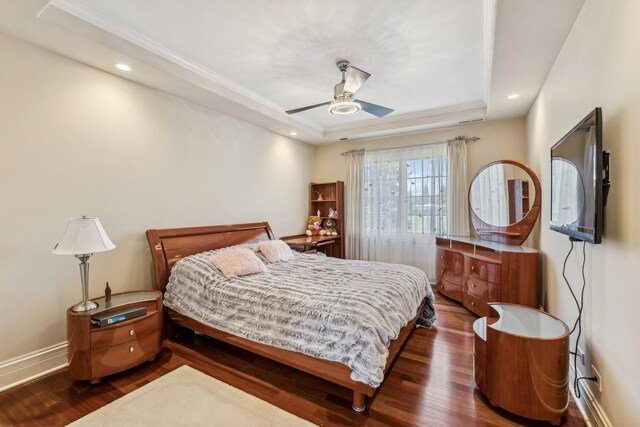 bedroom featuring ceiling fan, a raised ceiling, and dark hardwood / wood-style floors