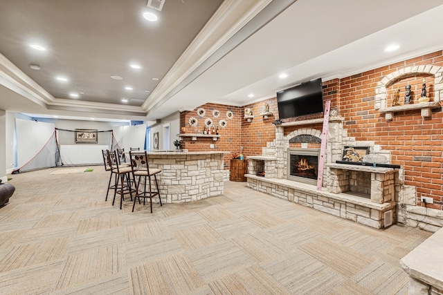 bar featuring light carpet, a tray ceiling, and brick wall