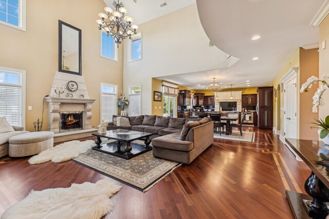 living room featuring a notable chandelier, a wealth of natural light, and dark hardwood / wood-style flooring