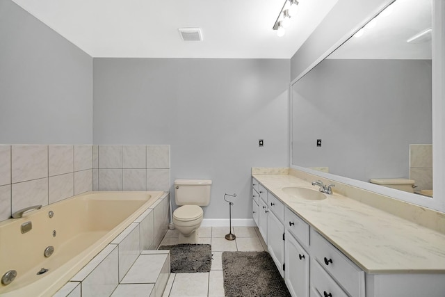 bathroom featuring toilet, vanity, tile patterned floors, and tiled tub