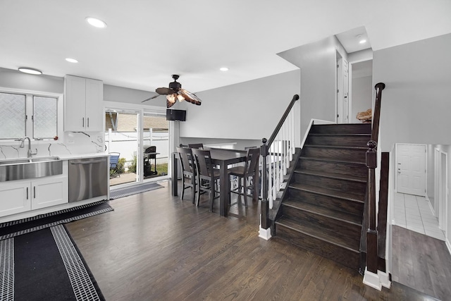 interior space with white cabinets, dishwasher, ceiling fan, and sink