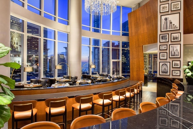 bar featuring a high ceiling and an inviting chandelier