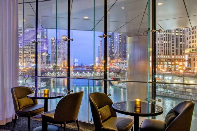 dining room with a water view and a wall of windows