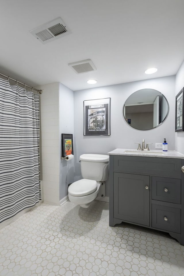 bathroom with toilet, recessed lighting, vanity, and visible vents
