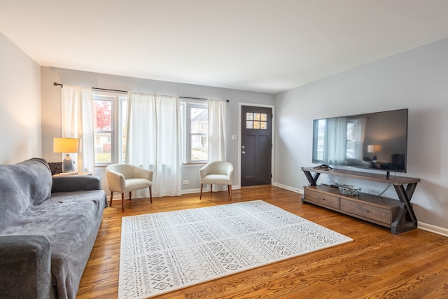living area with baseboards and wood finished floors