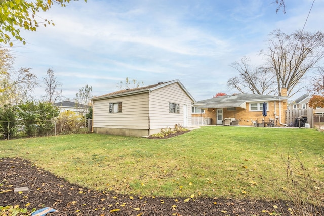 exterior space with a fenced backyard, a patio, and a yard