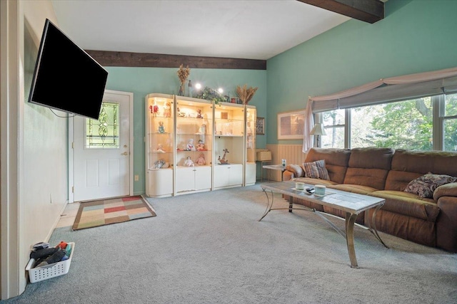 living area with beamed ceiling, a healthy amount of sunlight, and carpet floors