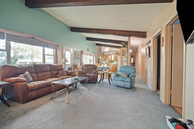 carpeted living area featuring beamed ceiling