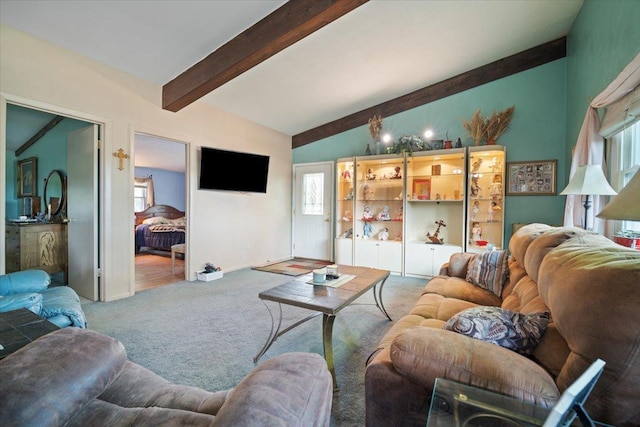 carpeted living room featuring lofted ceiling with beams and baseboards