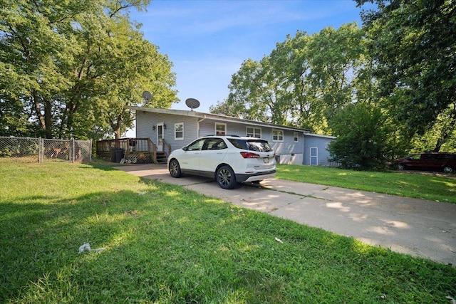 view of front facade with a deck, a front yard, a gate, and fence