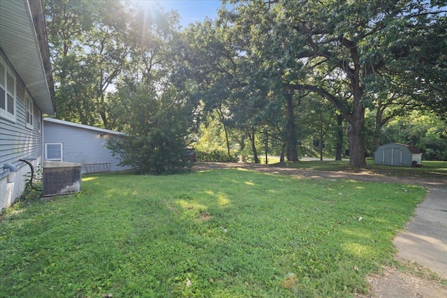 view of yard featuring an outbuilding, cooling unit, and a storage unit