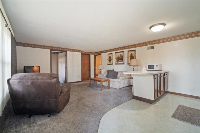 living area with visible vents, baseboards, and light colored carpet