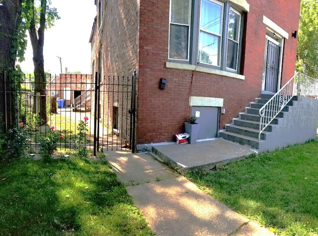 exterior space with a yard, brick siding, and fence