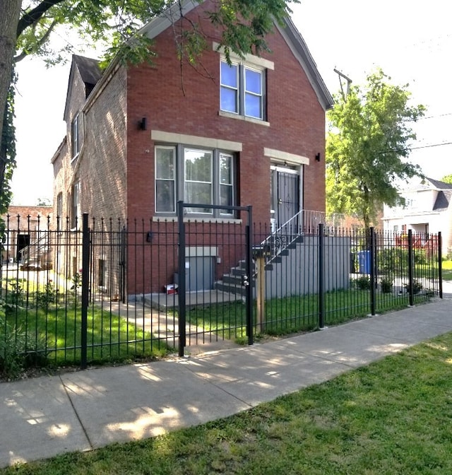 view of front of property featuring a fenced front yard and brick siding