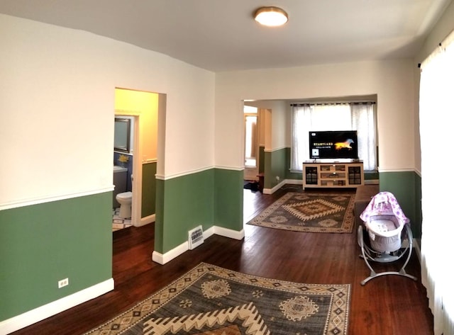 living room with visible vents, baseboards, and wood finished floors