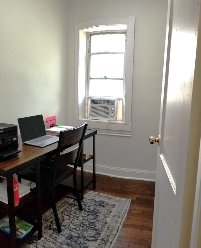 home office with cooling unit, baseboards, and wood finished floors