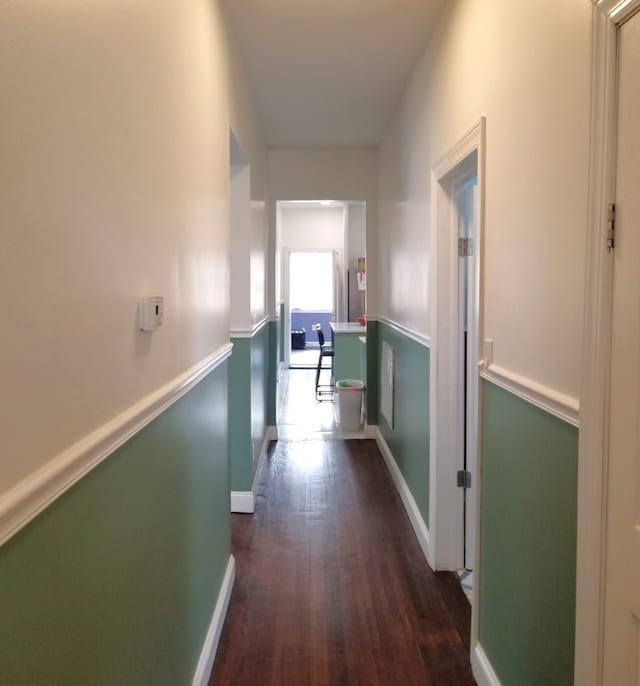 corridor with baseboards and dark wood-style flooring