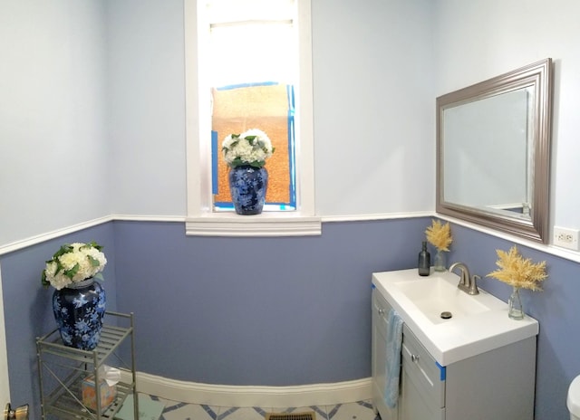 half bath with vanity and baseboards