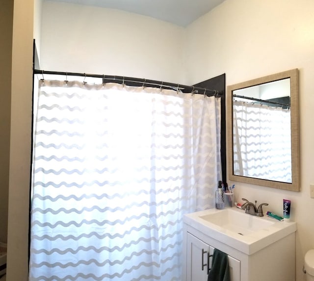 bathroom with toilet, vanity, and a shower with curtain