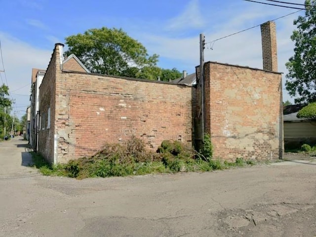 view of home's exterior with brick siding and a chimney