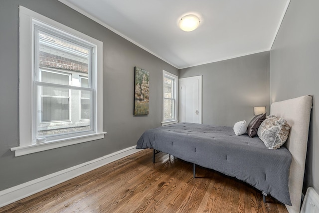 bedroom with wood-type flooring and ornamental molding