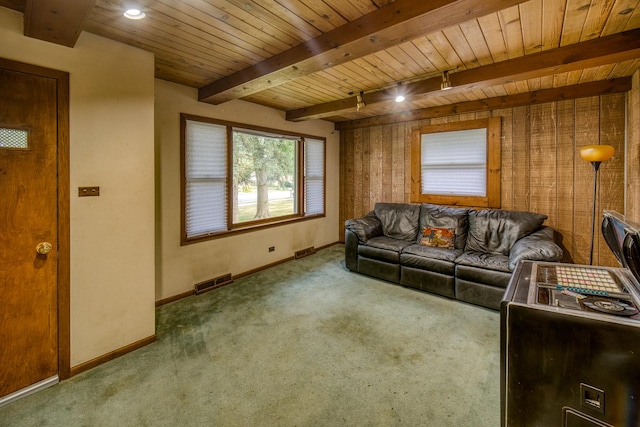 living room with wooden ceiling, track lighting, wooden walls, carpet flooring, and beam ceiling