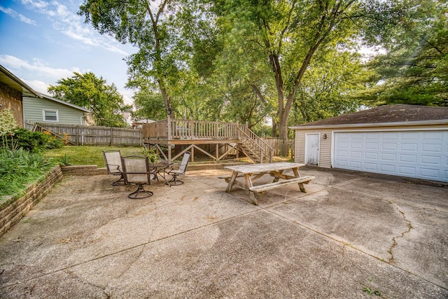 view of patio / terrace featuring a garage, an outdoor structure, and a wooden deck