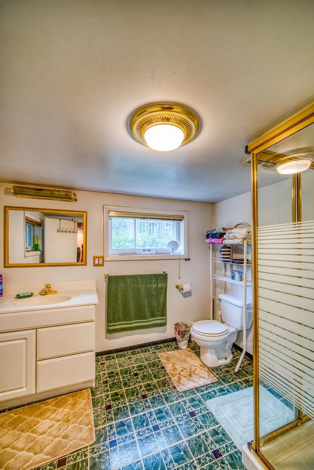 bathroom featuring vanity, an enclosed shower, and toilet