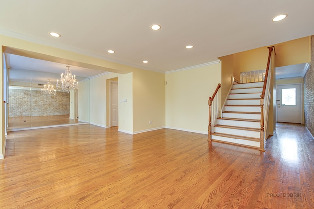 unfurnished living room featuring a notable chandelier, light hardwood / wood-style floors, and crown molding