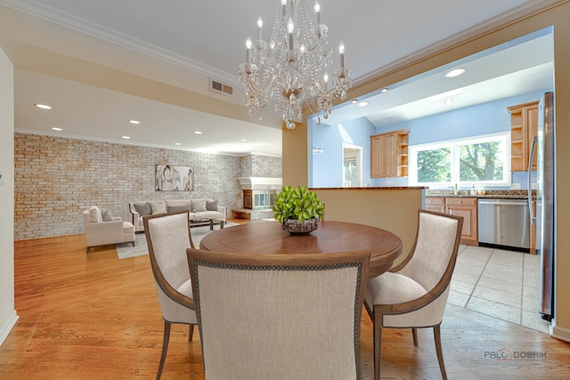 dining area featuring brick wall, light hardwood / wood-style flooring, and ornamental molding