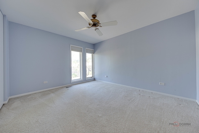 carpeted spare room featuring ceiling fan