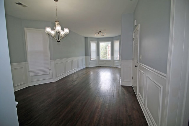 unfurnished dining area with a notable chandelier and dark hardwood / wood-style flooring