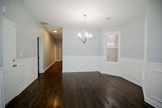 unfurnished dining area with a notable chandelier and dark wood-type flooring