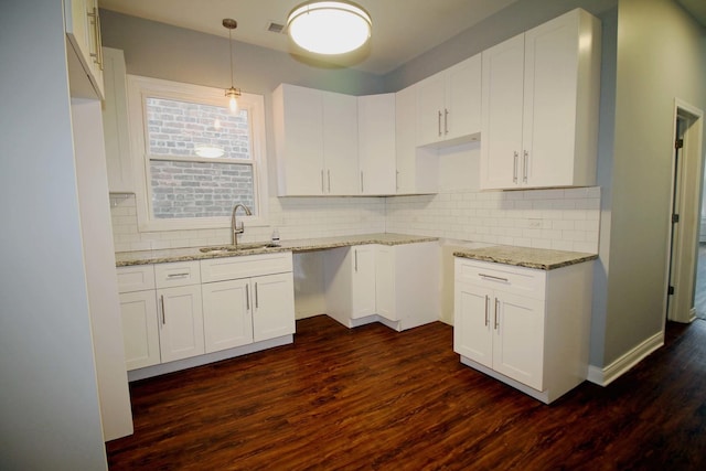 kitchen with white cabinets, hanging light fixtures, dark wood-type flooring, and sink