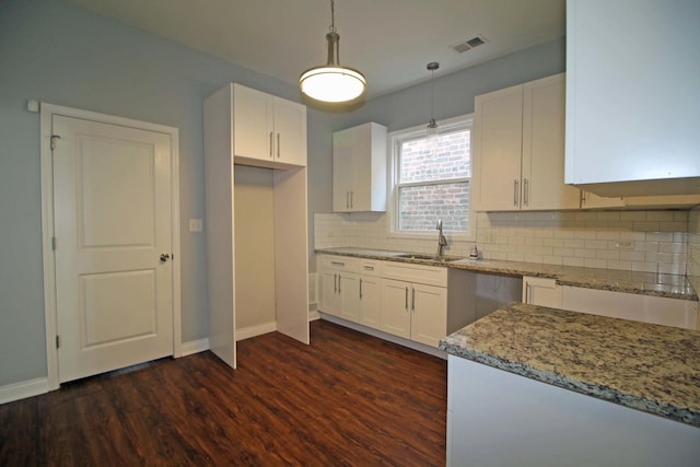 kitchen featuring white cabinets, sink, decorative backsplash, decorative light fixtures, and dark hardwood / wood-style flooring