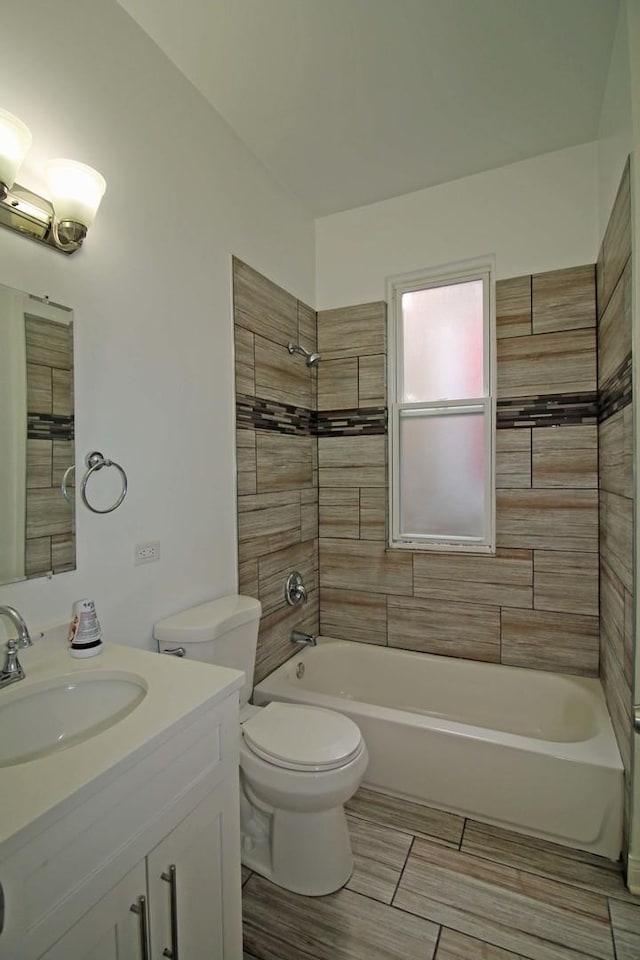 full bathroom with vanity, tiled shower / bath combo, and toilet