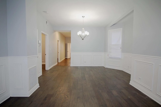 unfurnished dining area with dark hardwood / wood-style flooring and an inviting chandelier