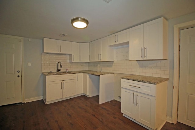 kitchen with white cabinets, sink, dark hardwood / wood-style floors, tasteful backsplash, and light stone counters