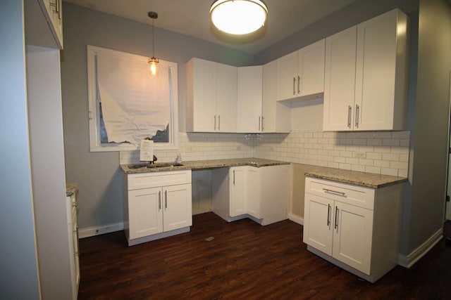 kitchen with decorative backsplash, dark hardwood / wood-style flooring, white cabinets, and decorative light fixtures