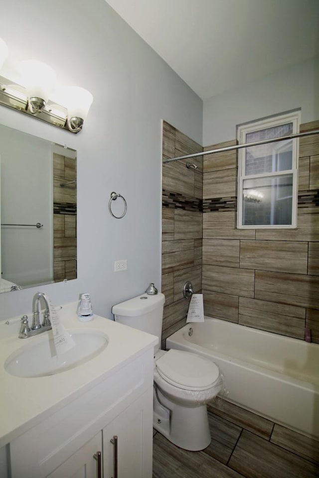 full bathroom with vanity, tiled shower / bath combo, and toilet