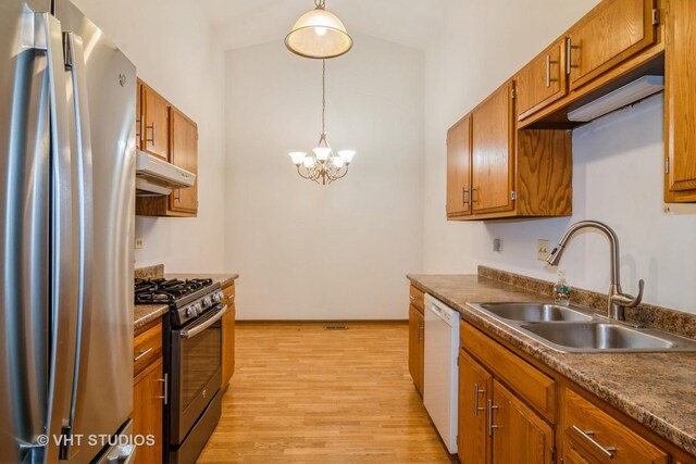 kitchen with light hardwood / wood-style flooring, range with gas stovetop, pendant lighting, sink, and stainless steel refrigerator