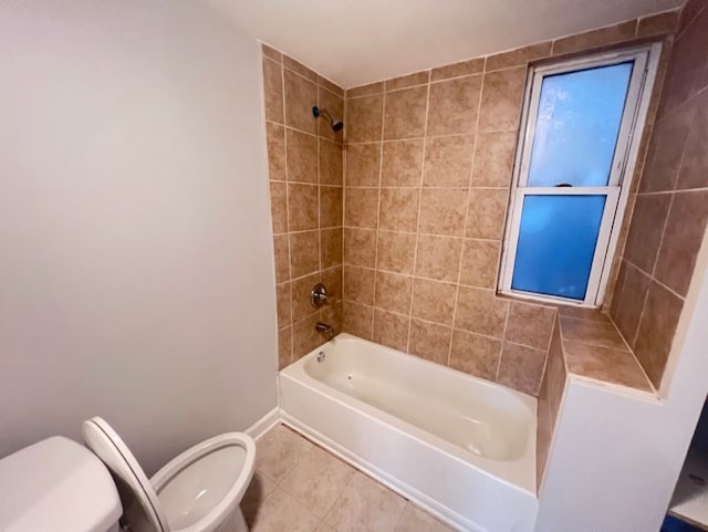 bathroom with tiled shower / bath, tile patterned floors, and toilet