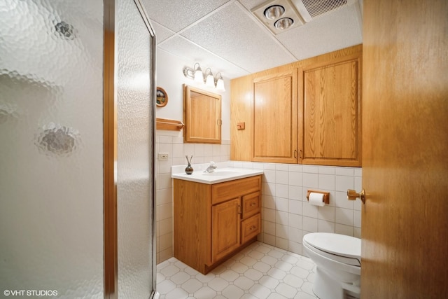 full bathroom featuring vanity, a shower stall, toilet, and tile walls