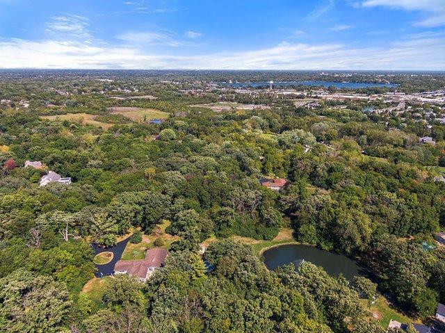 drone / aerial view featuring a forest view and a water view